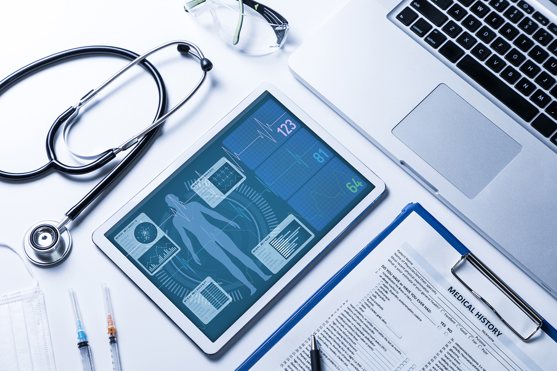 medical records, stethoscope, laptop, and tablet
